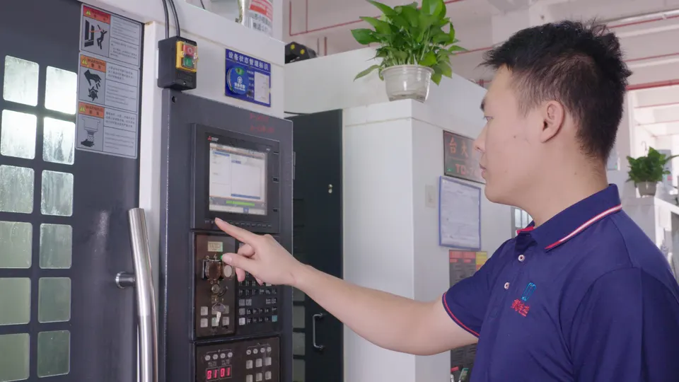 Operator entering settings at a CNC machine control panel