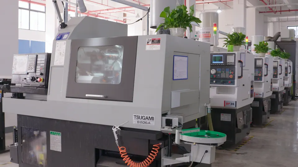 Row of enclosed CNC turning machines on the workshop floor