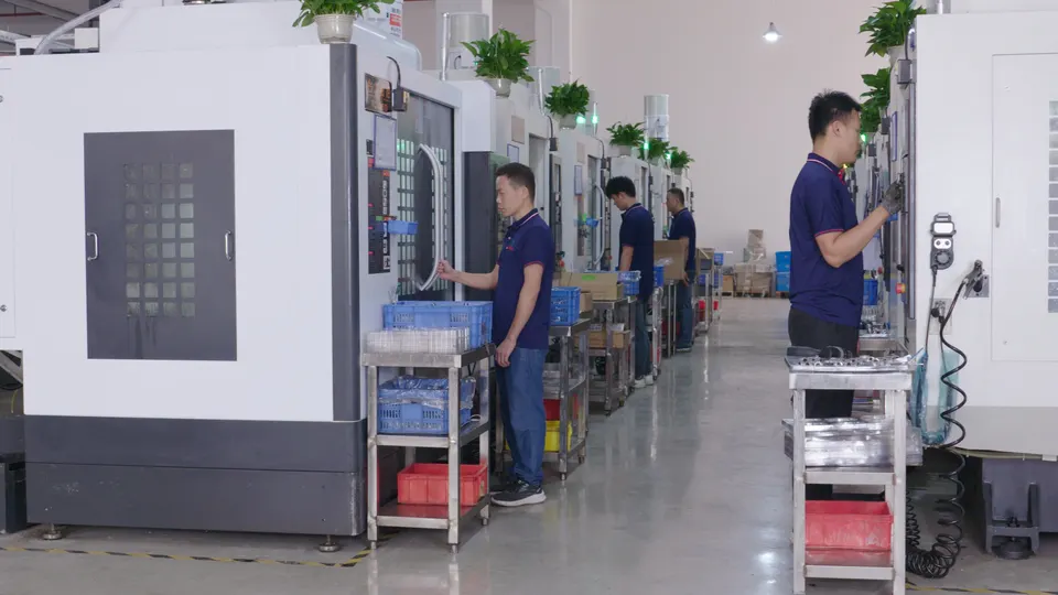 Machining operators working at CNC equipment along a production aisle