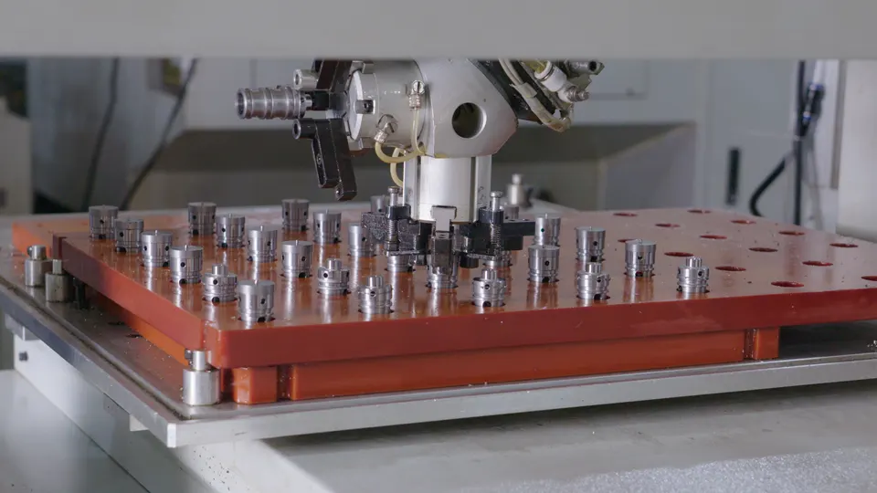 Multiple tool heads positioned over a production fixture inside machining equipment